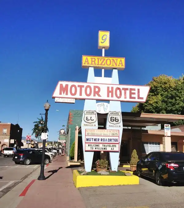 1960s geometric shapes on sign. Yellow cube with a number 9 on tip. Yellow box w/red letters spelling: ARIZONA, and white box w/red letters (MOTOR HOTEL) below. Oval US66 shields & 2 pylons