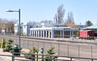 Classic stately pale blue bldg w/columns & arches by railway tracks