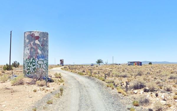 KOA campground in 2022 Two Guns. Route 66, Arizona Two Guns, abandoned campground two cylindric shaped water tanks, shrubs and road