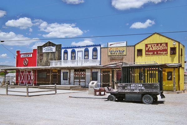 false building facades a mock wild west town in yellow, red: livery, gun shop, bank