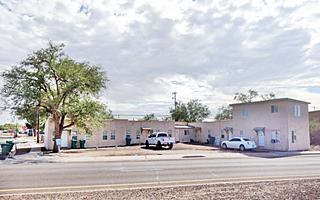 L-shaped apartment complex, cars, tree
