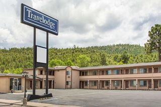 modern motel, forested hill behind 2 story building, TRAVELODGE sign