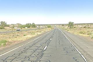 color photo looking along Westbound lanes I-40, arid scenery, cars west, trees