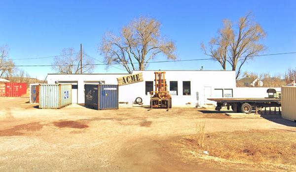 box shaped concrete block former gas station, containers, forklift, seen from Route 66