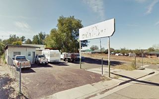 Richfield gas station, Ash Fork Route 66 small building in the corner, sign facing highway and some parked vehicles