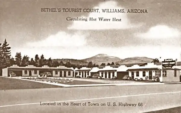 1940s sepia colored postcard: cornre motel w/garages by units, L-shaped layout
