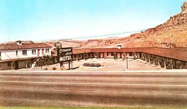 Spanish tiled gable roofed motel with circular layout on the side of a barren hill