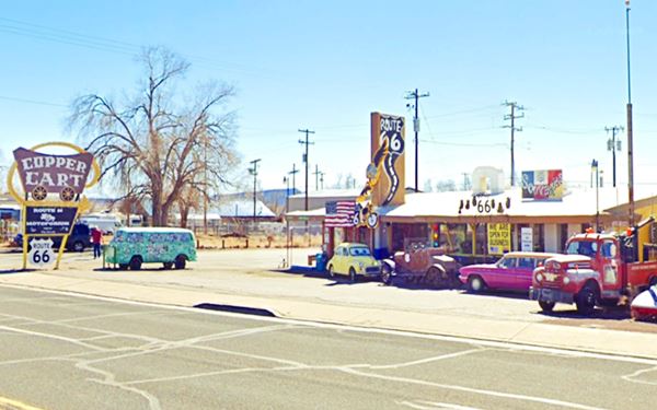 vintage cars, colorful store on a corner, neon sign with mining cart seen from US66