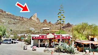 Elephants tooth mountain, Oatman mountain ridge with widhe white outcrop, buildings, cars and streets in the foreground