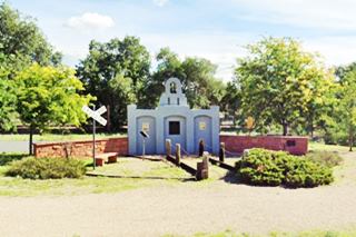 Escalante monument Ash Fork AZ monument painted gray, in a park, with marker plaques and small arched niches