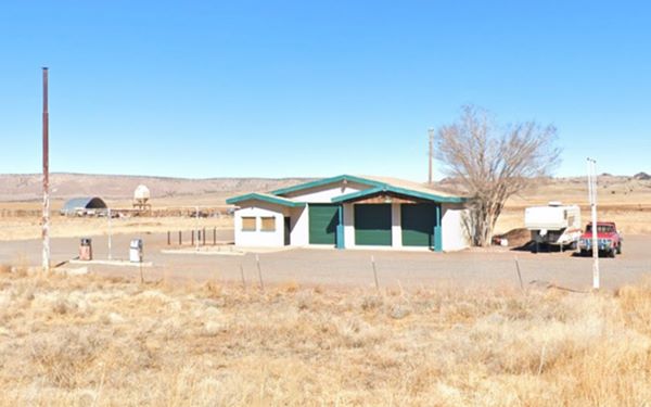 green gable roof, 3 service bay gas station with 2 pump islands, and 2 pumps