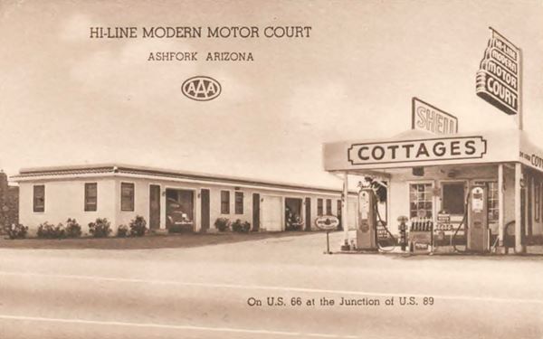 sepia postcard 1940s. Motel with neon sign, Shell gas station and car in garage by unit