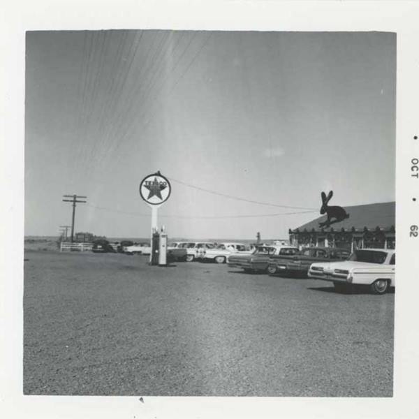 Texaco pumps, sign and cars at the Jack Rabbit Trading Post black and white photo