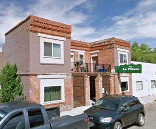 2 story box shaped brick bldg with recessed entrance and green sign