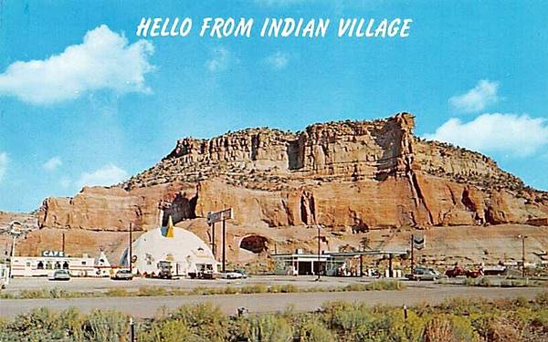 color postcard with: left to right, cafe, tepee, crested dome trading post and Chevron filling station. US 66 runs in the foreground, sandstone cliffs in the background. c.1970