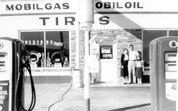 black and white 1950s picture of the Barkers standing 
in front of the Mobil gas station in Truxton