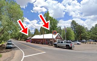 color view cars and wooden buildings in a pine forest seen from US66