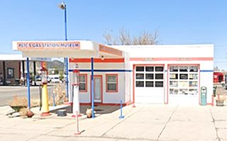 restored white & orange & blue Union 76 box shaped 1940s 
gas station, flat canopy, pumps, 2 service bays, office