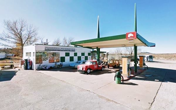 butterfly shaped canopy next to box-shaped gas station