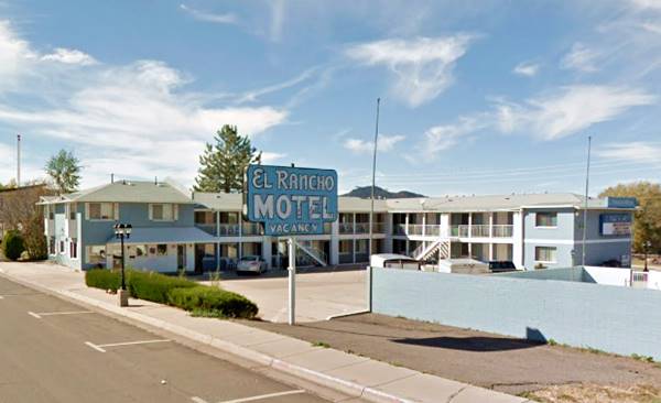 motel with blue neon sign and white letters, two story building seen from Route 66