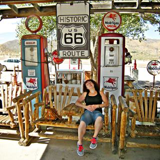 relaxing on a wooden bench by the old gas pumps in Hackberry slouching on a wood bench by the vintage signs and gas pumps