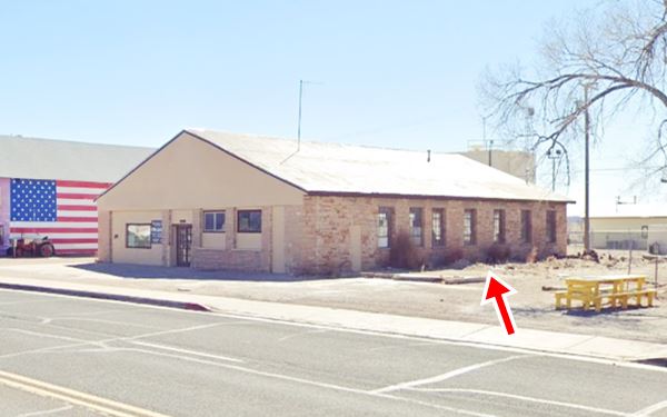stone building with multi-pane windows, gable roof seen from Route 66