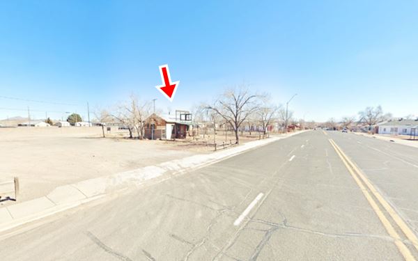 Route 66 in Seligman, old gable roof building, trees and Chino Ave.