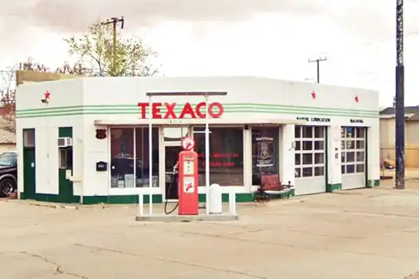 box shaped Texaco, red TEXACO sign atop an angled corner office, 2 service bays