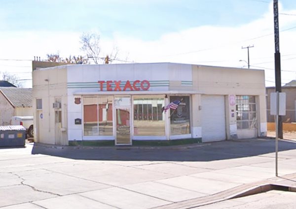 box shaped Texaco, red TEXACO sign atop an angled corner office, 2 service bays to the right
