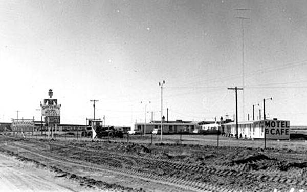Motel in a black and white postcard next to westbound lanes of freeway in 1962