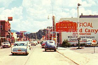 1950s photo. Cars, street, buildings, stores, motel sign