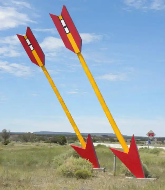 two giant arrows, painted red and yellow, stuck in the ground