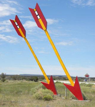 close up of the two giant arrows, painted red and yellow, stuck in the ground