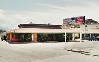 Trovatore Cafe hip roof bldg, sign and hill beyond