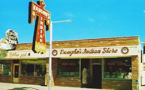 color postcard flagstone building, Thunderbird sign, 2 stores: cafe and Indian Store in the building