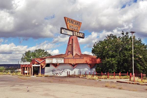 Vacant 16 sided building with broken sign atop its steeple