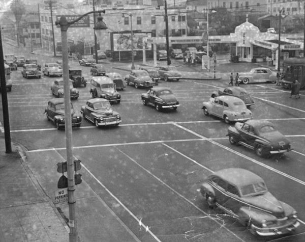 Sunset Blvd. and N Figueroa, 1948 Los Angeles CA Route 66 black and white photo, 1948, busy intersection with cars on both avenues, a tram on the right, and a gas station on the upper right corner