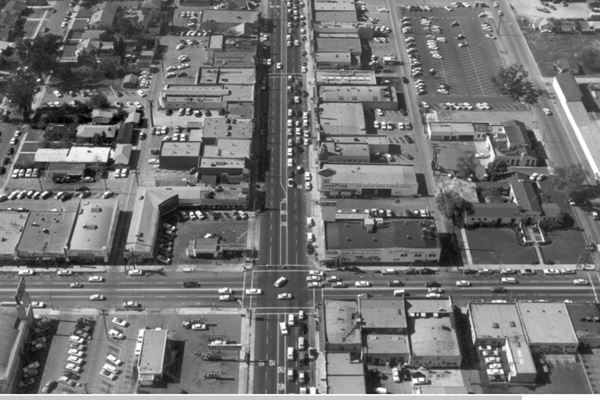 1955 aerial photo downtown Arcadia CA Route 66 looking west along Huntington at its intersection with 1st Ave. aerial view; cars, buildings, streets of Arcadia CA