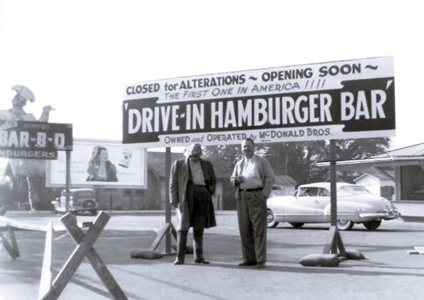 McDonalds bros. by their store 1948 two men, Dick and Mac McDonald in front of their restaurant, black and white 1948. sign behind them reads CLOSED FOR ALTERATIONS-OPENING SOON.