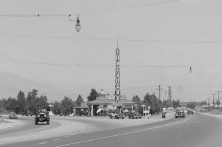 Fork at 4th and 5th Streets US 66 1938 Black and white looking east at fork of 4th and 5th Streets Richfield gas station with tower, cars, mountains in the distance 1938