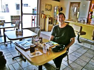 Austin Whittall in Ludlow Cafe man at a table in a Diner having a coffee