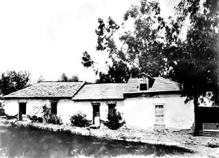 Flores Adobe, South Pasadena c.1900 black and white photo c.1900 of a single story adobe building with tiled roof, trees