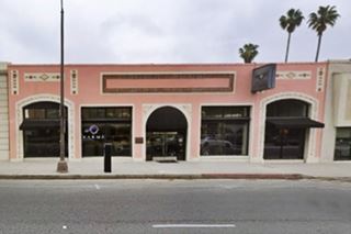 color, single story building, painted pink with 5 large glass windows facing the street