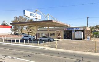 stone faced details, office, 2 service bays right, detached flat canopies held up by external trusses