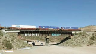 Alray viaduct nowadays, Cajon Pass color, train going over trestle crossing dirt surfaced highway, arid area