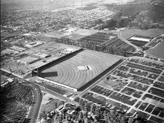 Azusa Foothill Drive-In, Azusa, looking northwest, 1963 black and white aerial view highways converge, drive-in theater, city and buildings beyond, and orange groves