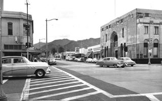 Looking north along Azusa Ave from Route 66 Azusa CA, 1954 black and white, cars and buildings looking along Azusa Ave from US 66, hills in the distance. 1954