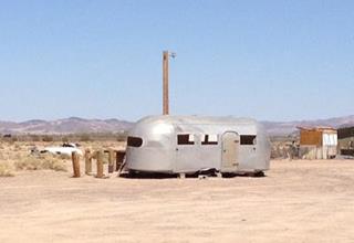 Bagdad Cafe Trailer aluminium caravan - trailer in the desert, shrubs and sand