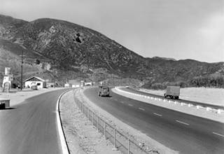 Blue Cut looking north along US66 black and white 1940s stores to the left, looking north along the highway. Mountains