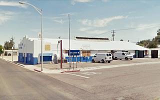 warehouse like building gable roof single story white and blue by Route 66 a former garage